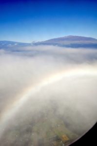 機内から見た虹。マウナ・ケアとマウナ・ロアも見えます